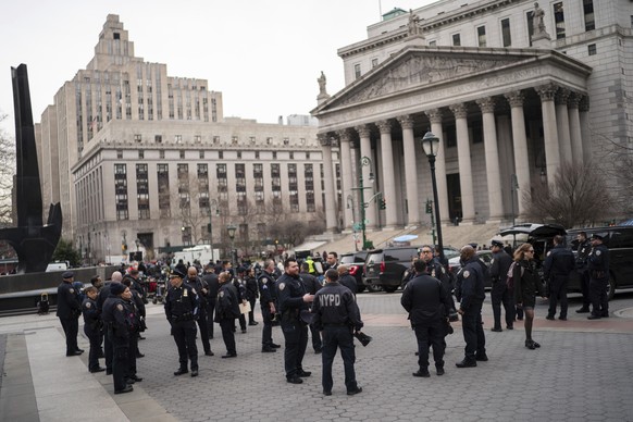 New York Police officers wait for instructions around the courthouse ahead of former President Donald Trump&#039;s anticipated indictment on Wednesday, March 22, 2023, in New York. A New York grand ju ...