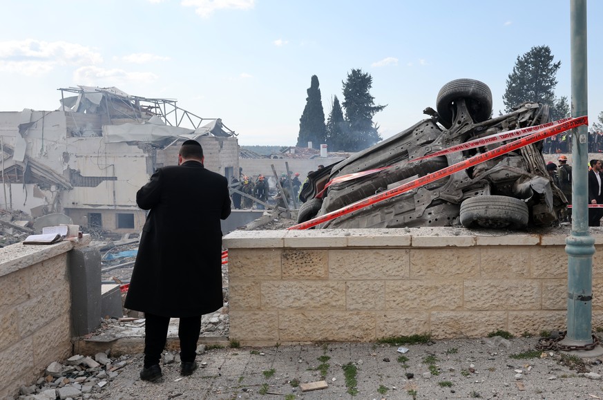 epa12787235 A man looks at debris following Iranian rocket attack that hit Beit Shemesh near Jerusalem, Israel, 01 March 2026. Israeli police confirmed at least six fatalities as a result of the Irani ...