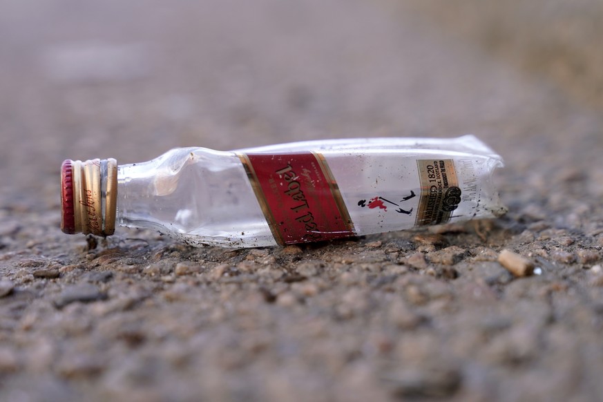 An empty miniature bottle that once contained liquor rests on a street near a sidewalk, Monday, April 3, 2023, in Boston. A Boston city councilor has proposed barring city liquor stores from selling t ...