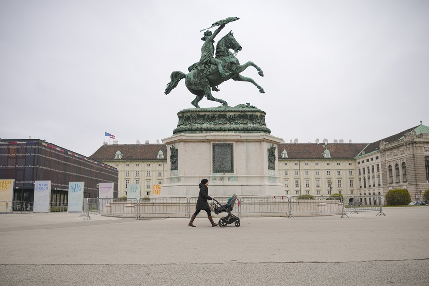 A woman pushes a baby stroller in Vienna, Austria, Monday, Nov. 22, 2021. Austria went into a nationwide lockdown early Monday to combat soaring coronavirus infections, a step being closely watched by ...