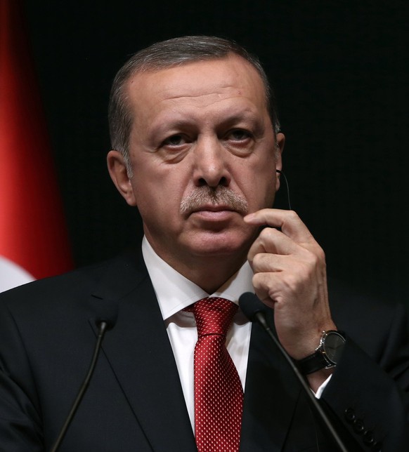 Turkish President Recep Tayyip Erdogan listens to his Russian counterpart Vladimir Putin during a joint news conference at the new Presidential Palace in Ankara, Turkey, Monday, Dec. 1, 2014. Putin ar ...