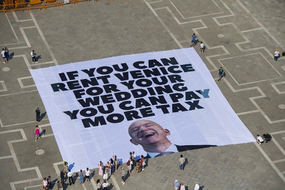 epa12192415 A handout photo made available by Greenpeace press office shows activists of the environmental group Greenpeace unfolding a giant banner with the image of US businessman and Amazon founder ...