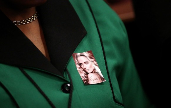 epa04110760 A member of the ANCWL (African National Congress Womens League) wears a picture with a face of the late Reeva Steenkamp as she attends Olympic and Paralympic track star Oscar Pistorius mur ...