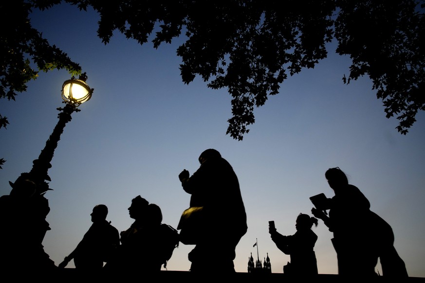 People queue to pay their respect to late Queen Elizabeth II who&#039;s lying in state at Westminster Hall in London, Wednesday, Sept. 14, 2022. The Queen will lie in state in Westminster Hall for fou ...