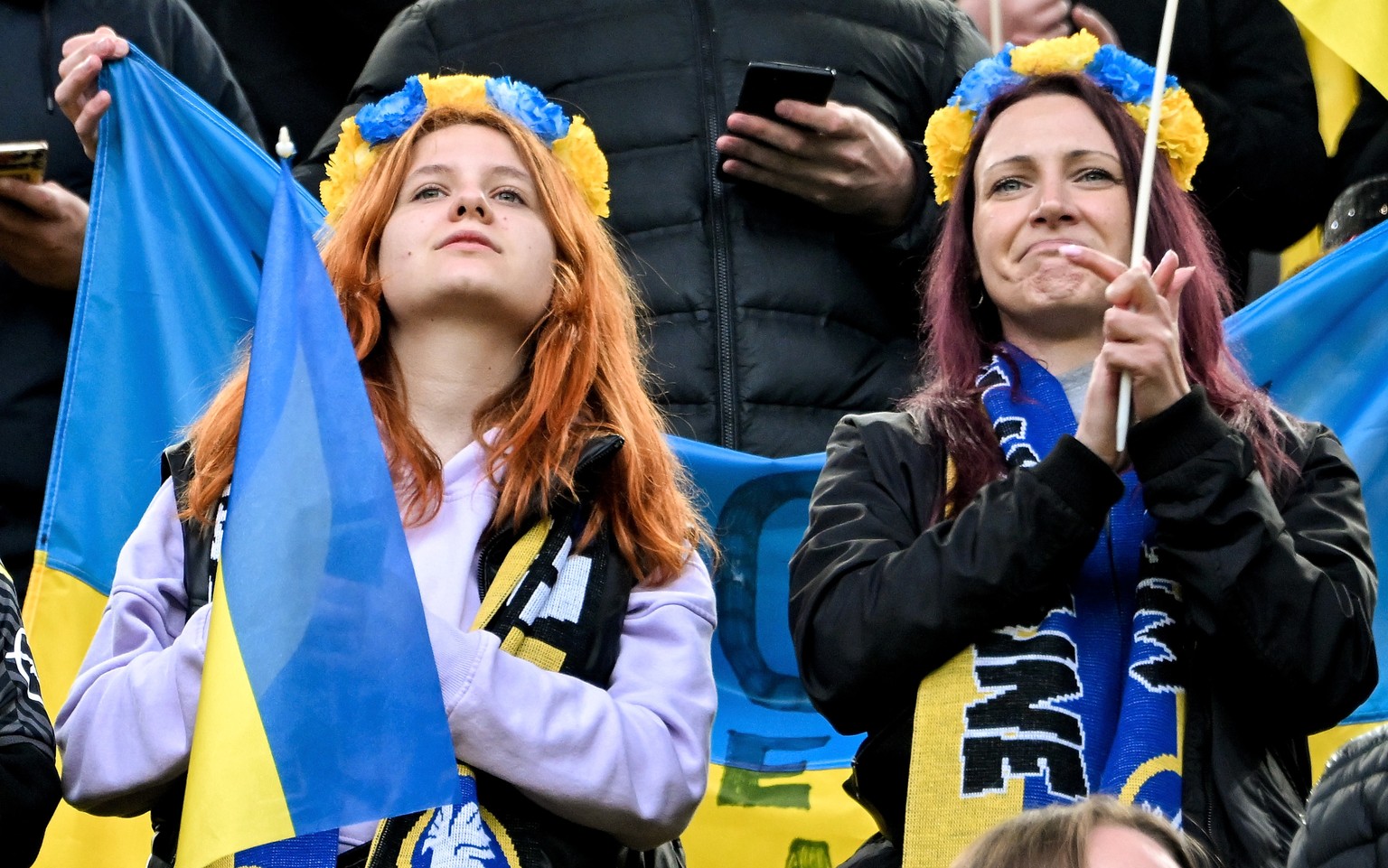 epa09910313 Fans of Germany and the Ukraine show flags and banners as they cheer on their teams during the benefit soccer match between Borussia Dortmund and Dynamo Kyiv at Signal Iduna Park in Dortmu ...