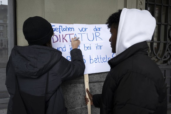 Eine Demonstrantin und ein Demonstrant bearbeiten ein Plakat vor, waehrend der Demonstration gegen die Schweizer Kollaboration mit dem eritreischen Regime und gegen die Passbeschaffungspflicht fuer Er ...