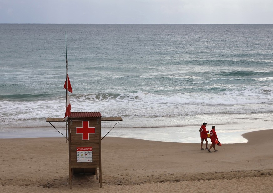 epa07832122 Two life guards walk along Cala dels Capellans beach in Tarragona, Spain, 10 September 2019. Strong rainfalls are expected in Catalonia during the day. EPA/Jaume Sellart