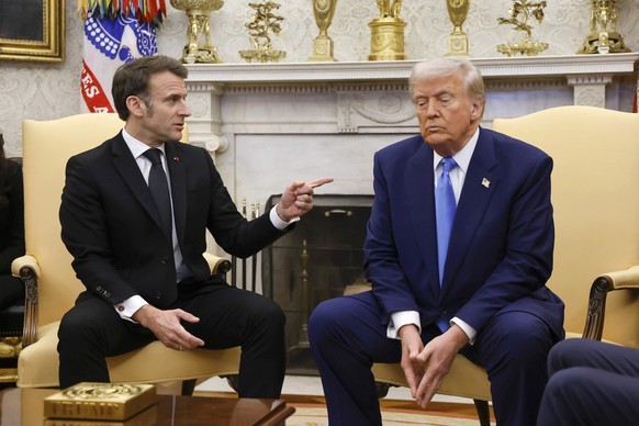 France's President Emmanuel Macron speaks as President Donald Trump listens during a meeting in the Oval Office of the White House in Washington, Monday, Feb. 24, 2025. (Ludovic Marin/Pool via AP ...