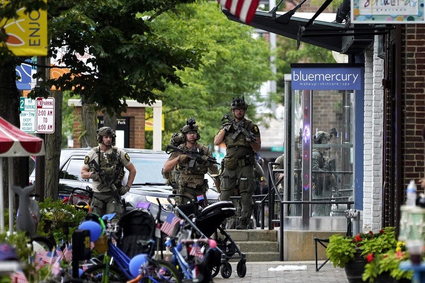 Law enforcement search after a mass shooting at the Highland Park Fourth of July parade in downtown Highland Park, Ill., Monday, July 4, 2022. A gunman on a rooftop opened fire on an Independence Day  ...