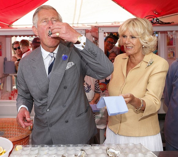 WHITSTABLE, UNITED KINGDOM - JULY 29: (EMBARGOED FOR PUBLICATION IN UK NEWSPAPERS UNTIL 48 HOURS AFTER CREATE DATE AND TIME) Prince Charles, Prince of Wales eats an oyster as Camilla, Duchess of Cornw ...