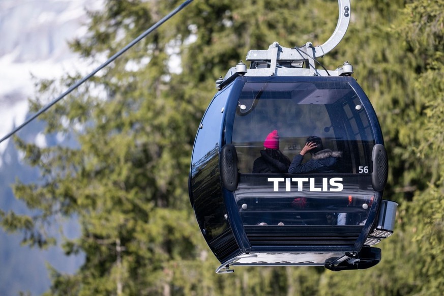 Tourists sit in a gondola cabin going down at the Titlis-Engelberg ski area in Engelberg, central Switzerland, on March 18, 2026, after a gondola cabin detached from its cable and crashed. (Photo by E ...