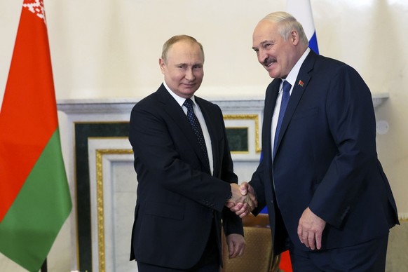 Russian President Vladimir Putin, left, and Belarusian President Alexander Lukashenko shake hands during their meeting in St. Petersburg, Russia, Saturday, June 25, 2022. (Mikhail Metzel, Sputnik, Kre ...