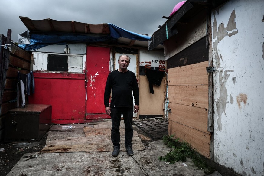 Vasile, un habitant du bidonville, pose pour une photo le 26 septembre 2025, au milieu des cabanes de Stains, une banlieue de Paris.