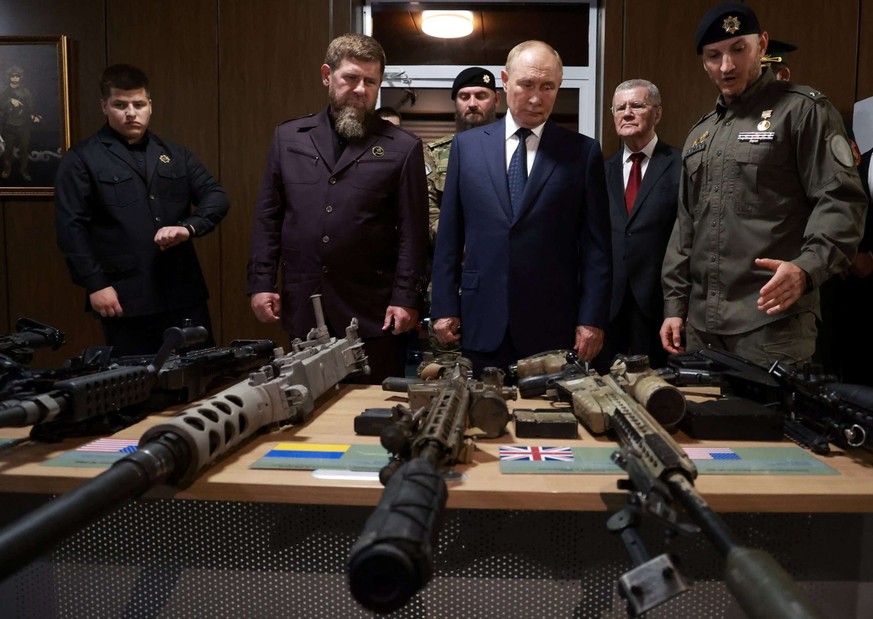 Sur cette photo collective diffusée par l'agence publique russe Sputnik, le président russe Vladimir Poutine (au centre) et le chef de la République tchétchène Ramzan Kadyrov (2e à gauche) visite ...