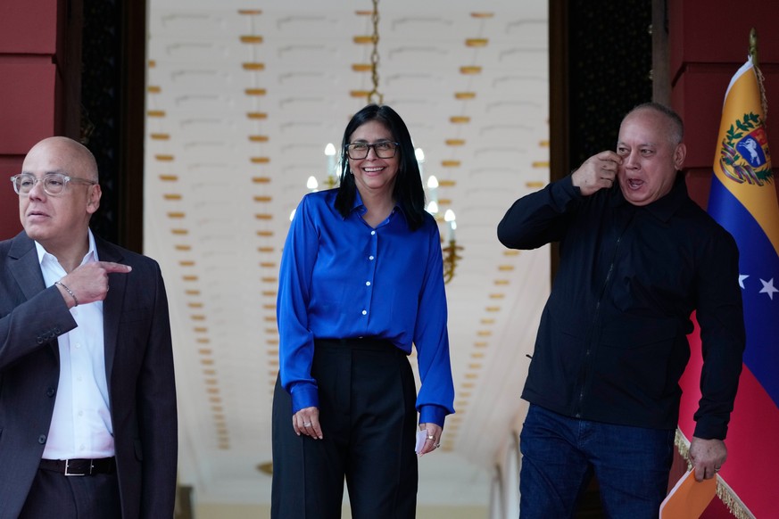 FILE - Venezuela's acting President Delcy Rodriguez, center, smiles flanked by Interior Minister Diosdado Cabello, right, and her brother, National Assembly President Jorge Rodriguez, after makin ...