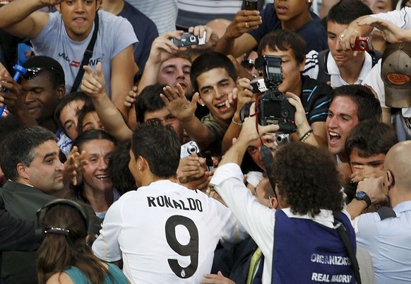 epa01785433 Real Madrid&#039;s new signing Portuguese striker Cristiano Ronaldo (9) gets off a stage placed at the Santiago Bernabeu stadium to get closer to the supporters during his official present ...