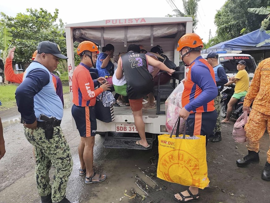 epa12513322 A handout photo made available by the Coast Guard District Southern Tagalog of the Philippine Coast Guard (PCG) shows PCG personnel assisting residents in pre-emptive evacuation measures i ...