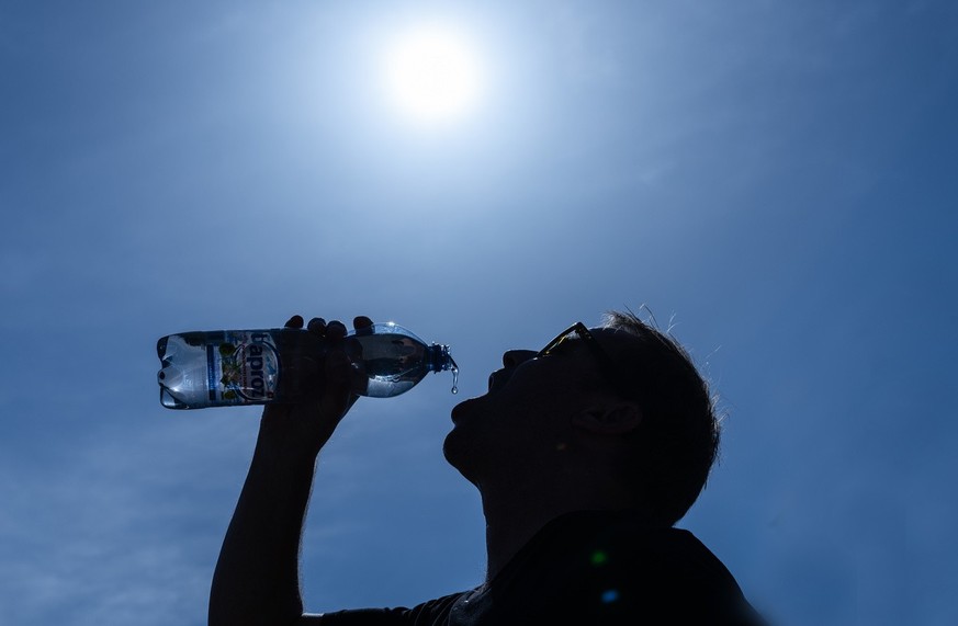 Un homme se rafraîchit avec un verre, le vendredi 17 juin 2022, à Thoune. Des températures supérieures à 30 degrés sont attendues pour les prochains jours.