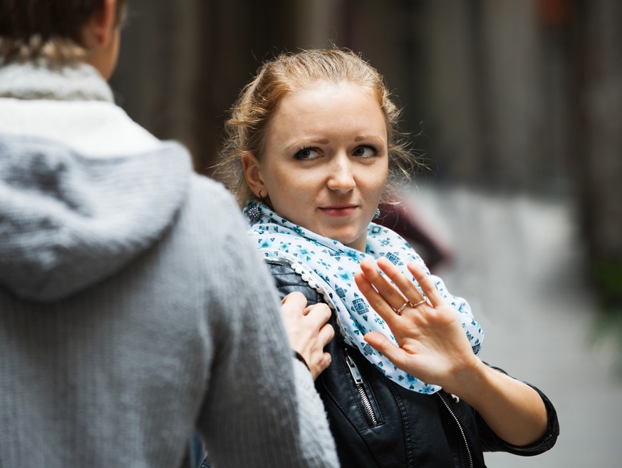 une jeune femme refuse les avances d&#039;un homme dans la rue