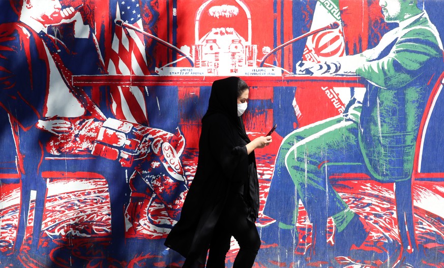 epa10160876 An Iranian woman walks past an anti-US wall painting on the wall of former US embassy in the capital city of Tehran, Iran, 05 September 2022. Following the indirect exchange of responses t ...