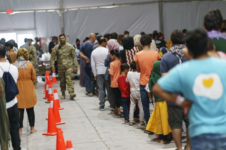 Afghan refugees line up for food in a dining hall at Fort Bliss&#039; Doña Ana Village, in New Mexico, where they are being housed, Friday, Sept. 10, 2021. The Biden administration provided the first  ...