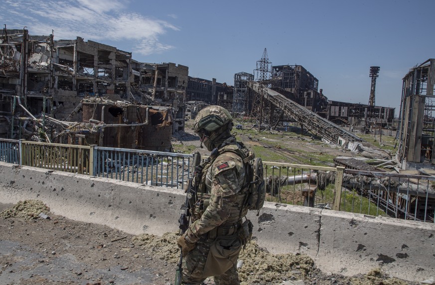 epa10011325 A picture taken during a visit to Mariupol organized by the Russian military shows a Russian serviceman inspects an area of the Azovstal steel plant in Mariupol, eastern Ukraine, 13 June 2 ...