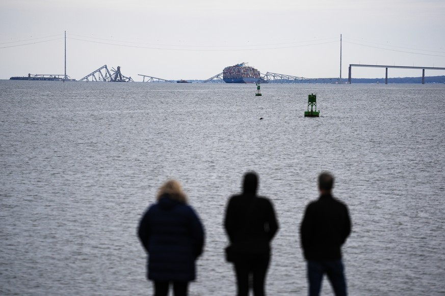 People view from Fort McHenry a container ship as it rests against the wreckage of the Francis Scott Key Bridge on Thursday, March 28, 2024, in Baltimore, Md. The ship rammed into the bridge early Tue ...