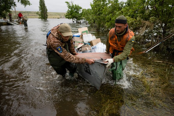 epaselect epa10687393 Volunteers deliver humanitarian aid to local residents in the village of Afanasiivka, Mykolaiv region, Ukraine, 12 June 2023, amid floods following the collapse of a major dam. U ...