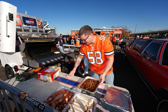 Nathan Hocking, of Pueblo, Colo., prepares food for a tailgate party outside Empower Field at Mile High before the Denver Broncos host the Las Vegas Raiders in an NFL football game Thursday, Nov. 6, 2 ...