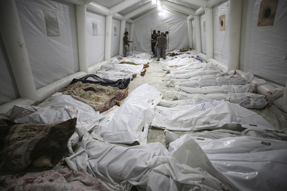 Bodies of Palestinians killed by an Israeli airstrike that hit the Ahli Arab hospital are seen gathered at the front yard of the al-Shifa hospital, in Gaza City, central Gaza Strip, Tuesday, Oct. 17,  ...