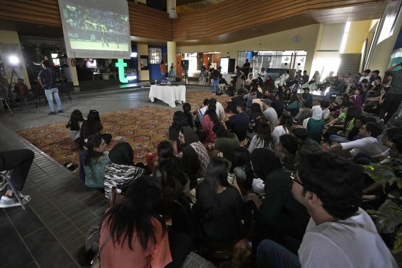 Cricket fans watch the ICC Champions Trophy cricket match between Pakistan and India on a big screen at a university campus, in Karachi, Pakistan, Sunday, Feb. 23, 2025. (AP Photo/Fareed Khan)