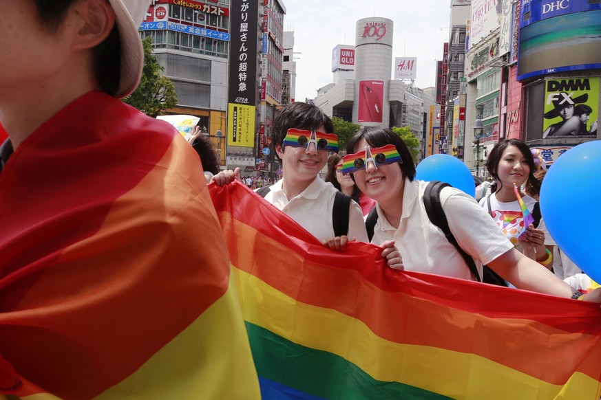 FILE - Participants smile as they march with a banner during the Tokyo Rainbow Pride parade celebrating the LGBTQ community May 7, 2017, in Tokyo&#039;s Shibuya district. Singapore���s announcement Su ...