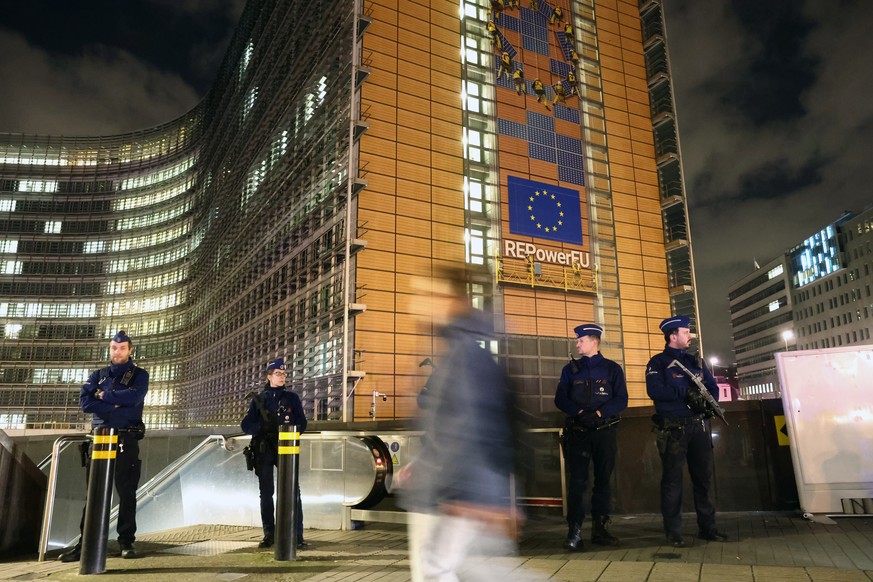 Des policiers armés montent la garde près de la gare Schuman après une attaque au couteau, à Bruxelles.