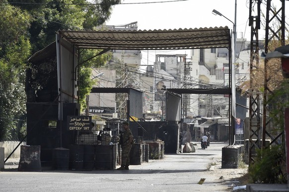 epa10848761 Lebanese army soldiers stand guards at the entrance of Ain el-Hilweh Palestinian refugee camp after clashes between supporters of the Fatah movement and rival groups erupted, in Sidon, Leb ...