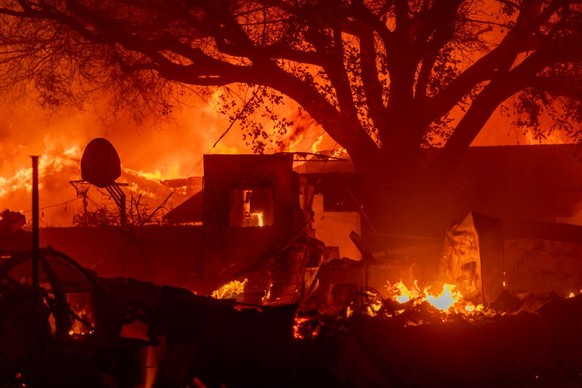 PASADENA, CALIFORNIA - JANUARY 7: Homes burn as powerful winds drive the Eaton Fire on January 7, 2025 in Pasadena, California. A powerful Santa Ana wind event has dramatically raised the danger of wi ...