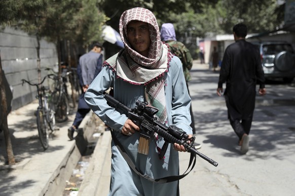 A Taliban fighter stands guard at a checkpoint in the Wazir Akbar Khan neighborhood in the city of Kabul, Afghanistan, Sunday, Aug. 22, 2021. A panicked crush of people trying to enter Kabul's interna ...