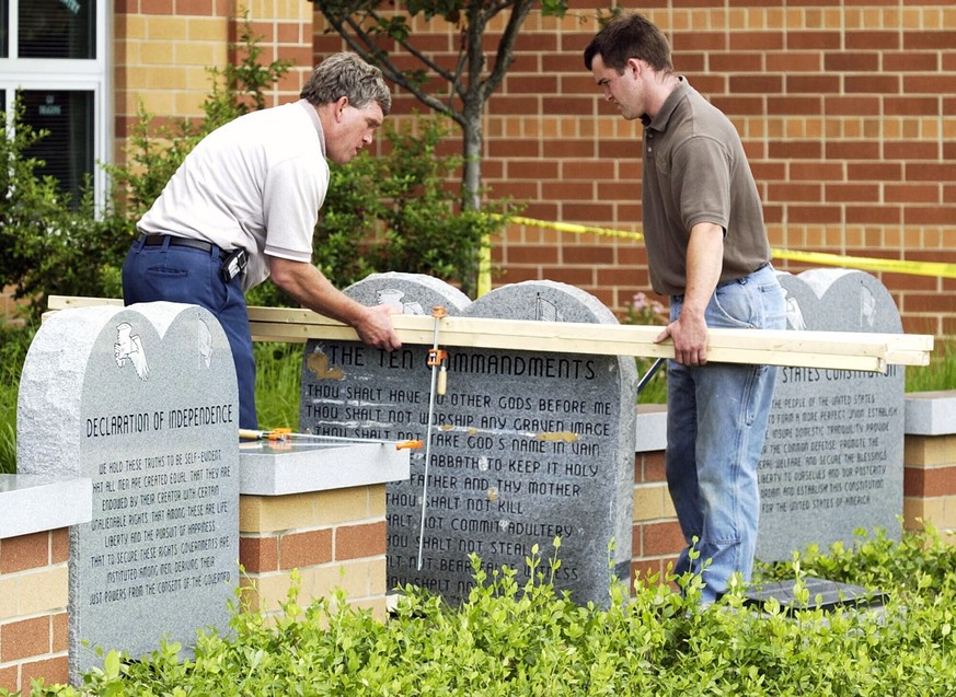 FILE - Workers remove a monument bearing the Ten Commandments outside West Union High School, Monday, June 9, 2003, in West Union, Ohio. Louisiana has become the first state to require that the Ten Co ...