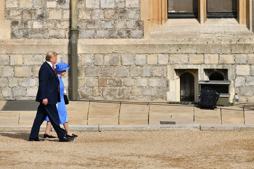 WINDSOR, ENGLAND - JULY 13: Britain&#039;s Queen Elizabeth II (R) walks with US President Donald Trump (L) in the Quadrangle at Windsor Castle on July 13, 2018 in Windsor, England. Her Majesty welcome ...