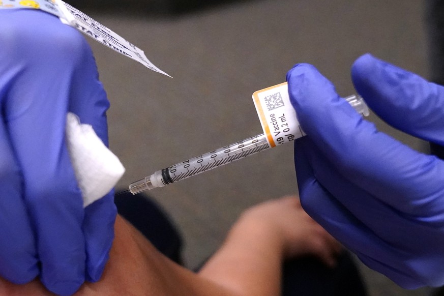 A child receives a second dose of the Pfizer COVID-19 vaccine at Northwest Community Church in Chicago, Saturday, Dec. 11, 2021. Pfizer is adding an extra dose of its COVID-19 vaccine for babies and p ...