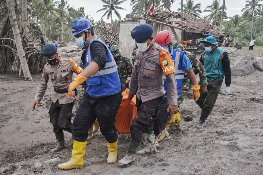 Les sauveteurs transportent le corps d&#039;une victime dans une zone touchée par l&#039;éruption du mont Semeru à Lumajang, Java oriental, Indonésie, 06 décembre 2021.