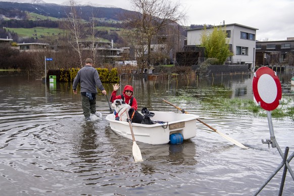 Quartierbewohner padeln waehrend des Hochwassers mit ihrem Boot zu ihrer Wohnung im Quartier Ried in Giswil am Sarnersee im Kanton Obwalden, am Mittwoch, 13. Dezember 2023 in Giswil im Kanton Obwalden ...