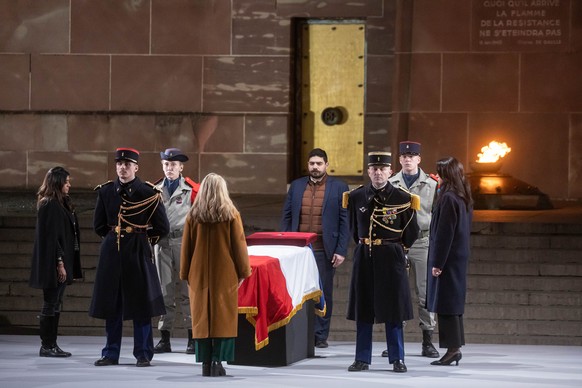 epa11168626 French Secretary of State for Veterans and Memory Patricia Miralles (back) and French state secretary for Housing Guillaume Kasbarian (C), stand in front of the flag drapped coffin of Miss ...