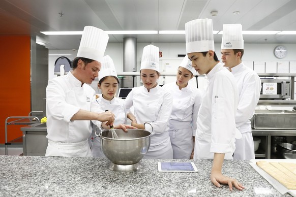 A head chef, left, teaches students in the kitchen of the restaurant at the hospitality management school Ecole Hoteliere de Lausanne in Lausanne, Canton of Vaud, Switzerland, on May 18, 2017. Founded ...