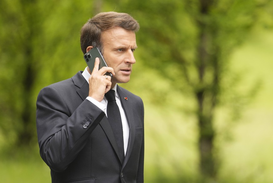 French President Emmanuel Macron speaks on a mobile phone as he walks to a media conference at the G7 venue, Castle Elmau, in Kruen, Germany, on Tuesday, June 28, 2022. The Group of Seven leading econ ...