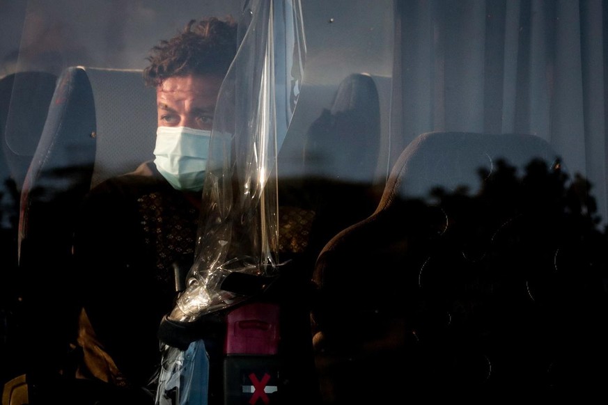 epa09427046 People sit on a bus after disembarking an Air Belgium evacuation flight arriving from Afghanistan at Melsbroek Military Airport, in Melsbroek, Belgium, 24 August 2021. The plane carried mo ...