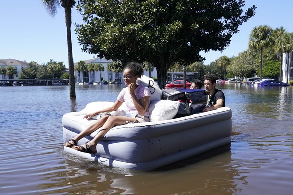 University of Central Florida students use an inflatable mattress as they evacuate an apartment complex near the campus that was totally flooded by rain from Hurricane Ian, Friday, Sept. 30, 2022, in  ...