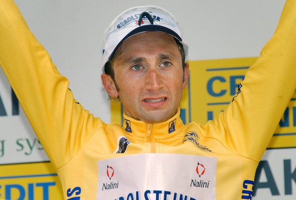 New overall leader Davide Rebellin of Italy, wearing the overall leader&#039;s yellow jersey, waves from the podium after winning the second stage of the Paris-Nice cycling race between La Clayette an ...