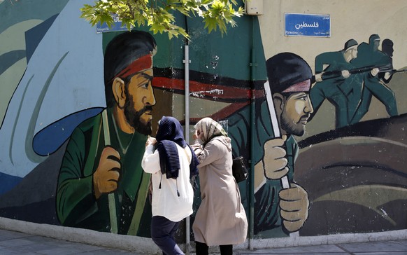 epa11277899 Iranian women walk past a wall painting of Iranian revolutionary gaurd corps (IRGC) soldiers in Tehran, Iran, 14 April 2024. Iran&#039;s Islamic Revolutionary Guards Corps (IRGC) launched  ...