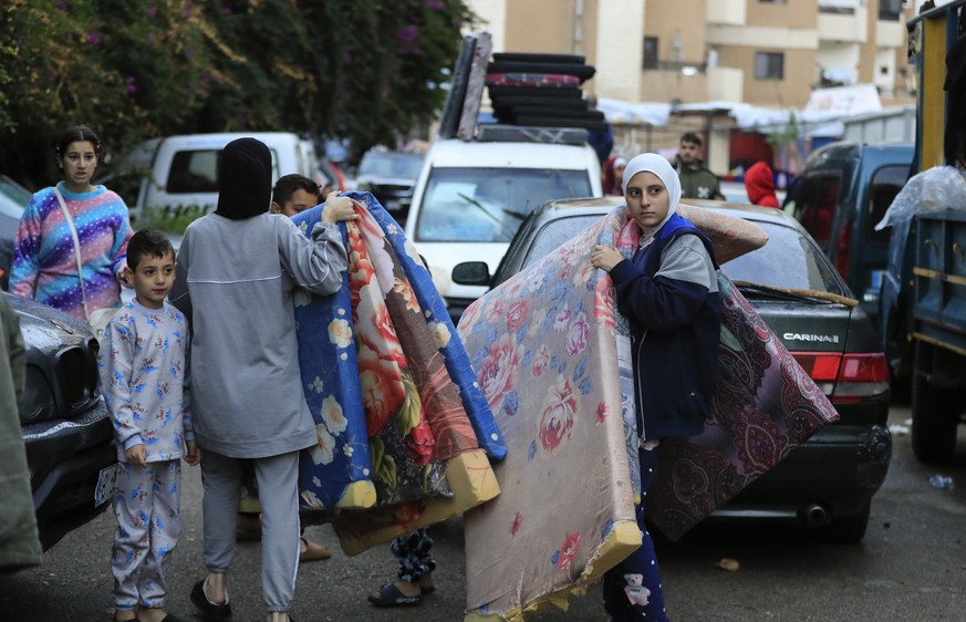 Displaced families carry mattresses as they prepare to return to their villages after a ceasefire between Israel and Hezbollah went into effect in Sidon, Lebanon, Wednesday, Nov. 27, 2024. (AP Photo/M ...