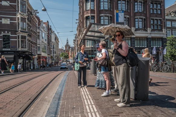 epa13066626 Tourists wait for the tram in Amsterdam, The Netherlands, June 26, 2026. A code red warning is in effect nationwide due to extreme heat. EPA/Joris van Gennip